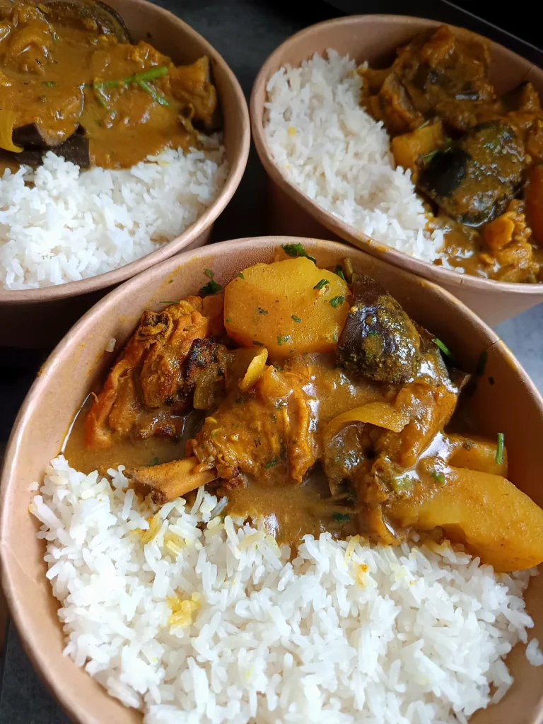 Bols traiteur de riz blanc accompagnés d’un plat mijoté créole en sauce