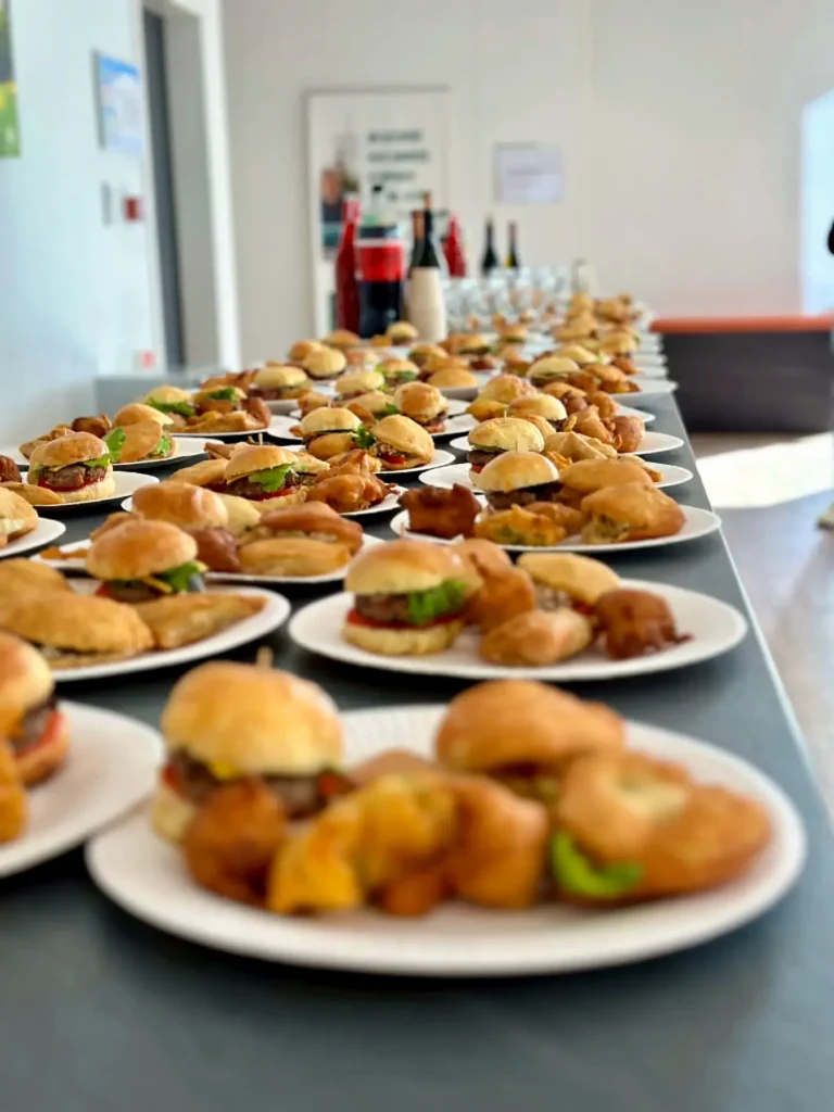 Buffet cocktail dressé avec mini-burgers, accras, samoussas et boissons
